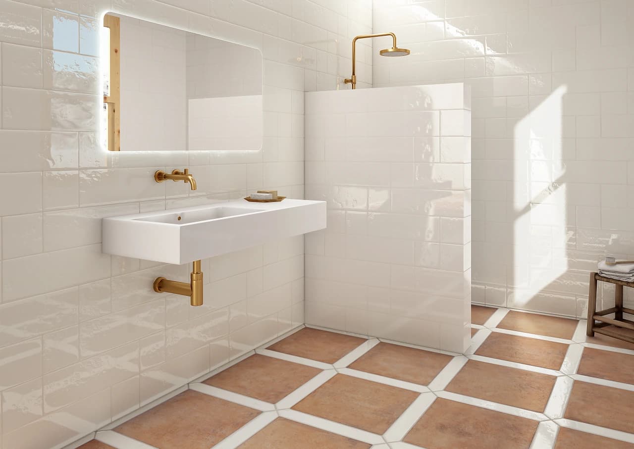 Sunlit bathroom with hand-glazed white tile walls and a terracotta checkerboard floor